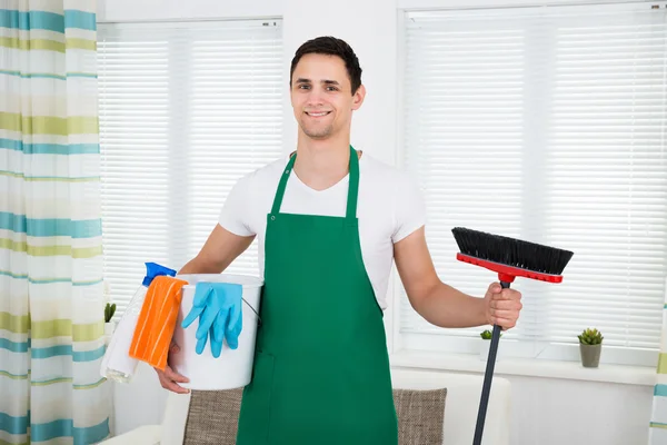 Uomo in possesso di attrezzature per la pulizia a casa — Foto Stock