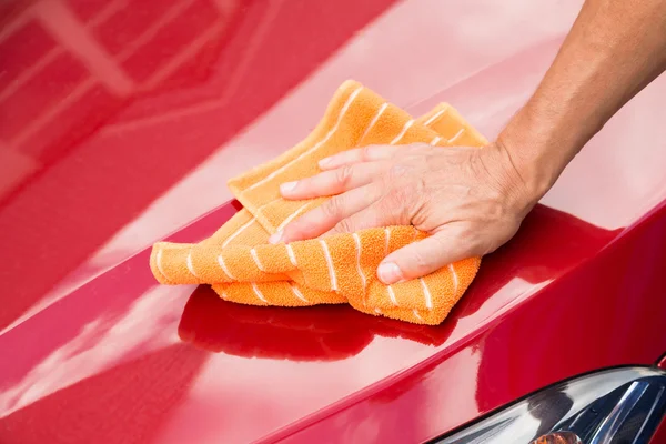 Mannelijke werknemer wassen rode auto Hood — Stockfoto