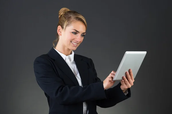 Femme d'affaires souriante utilisant une tablette numérique — Photo