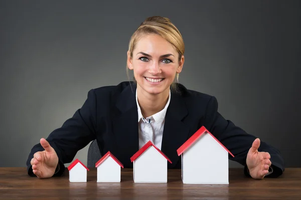 Affärskvinna med modell hus — Stockfoto