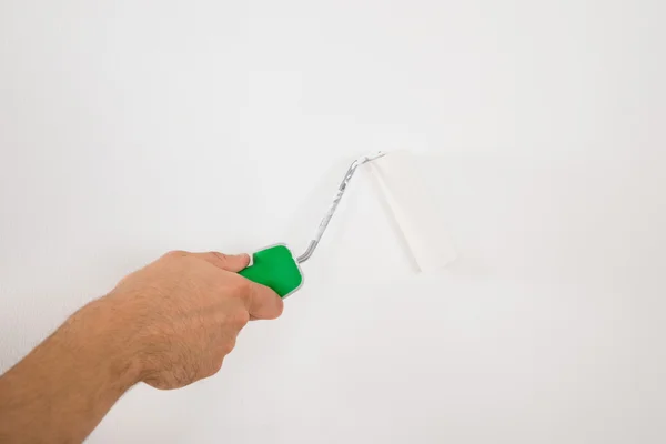 Homme utilisant rouleau de peinture sur le mur — Photo