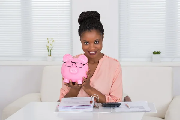Nő a gazdaság Piggybank, szemüvegek — Stock Fotó