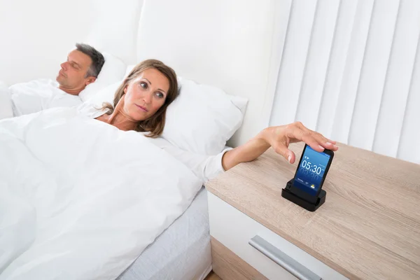 Mulher na cama roncando relógio de alarme — Fotografia de Stock