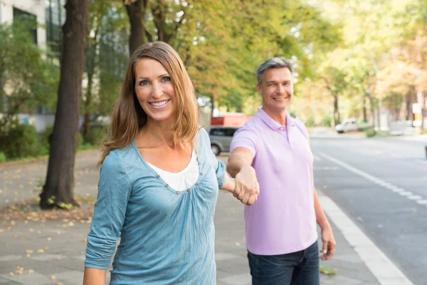 Uomo tirando donna in il strada — Foto Stock