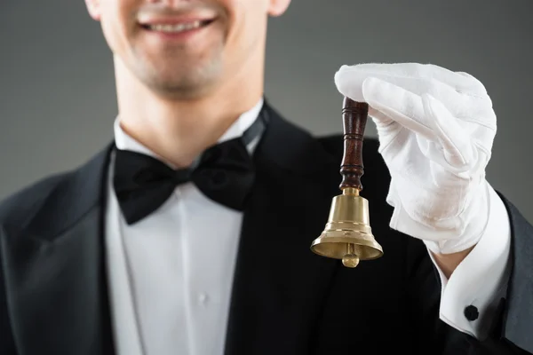 Midsection del camarero que sostiene la campana del anillo — Foto de Stock