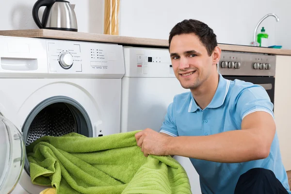 Man laddar handdukar i tvättmaskin — Stockfoto