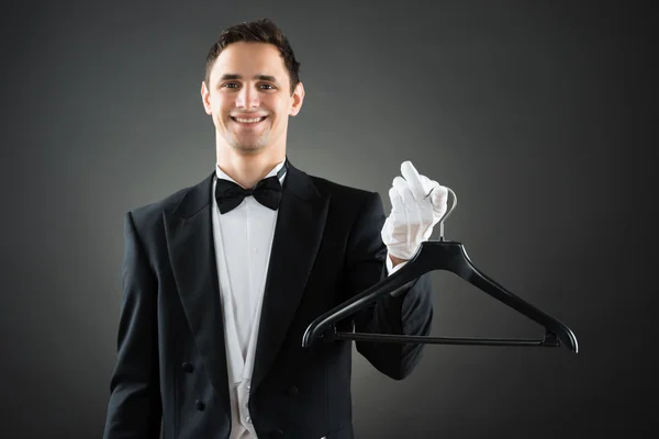 Retrato de feliz ama de llaves que sostiene la percha —  Fotos de Stock