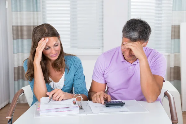 Pareja preocupada mirando las facturas impagadas — Foto de Stock