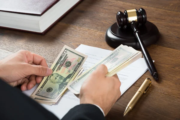 Корупційний суддя підрахував гроші на робочому столі — стокове фото