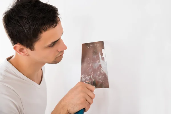 Homme utilisant un couteau à mastic — Photo