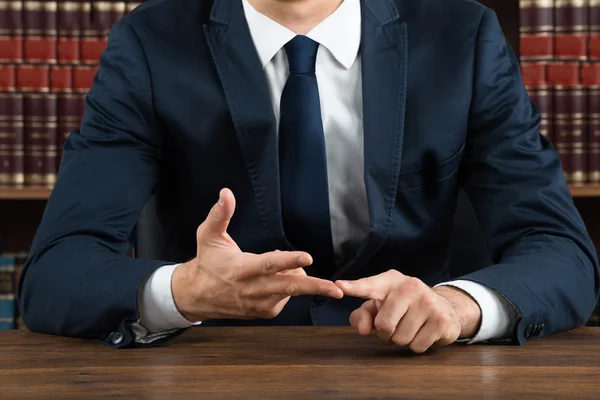 Anwalt gestikuliert am Schreibtisch — Stockfoto