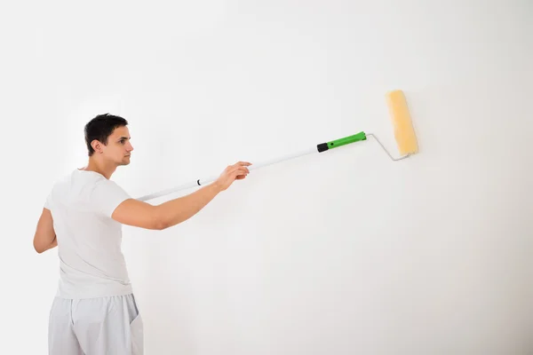 Homem usando rolo de tinta — Fotografia de Stock