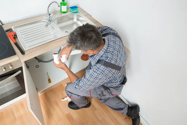 Plumber Fixing Sink Pipe In Kitchen — Stock Photo, Image
