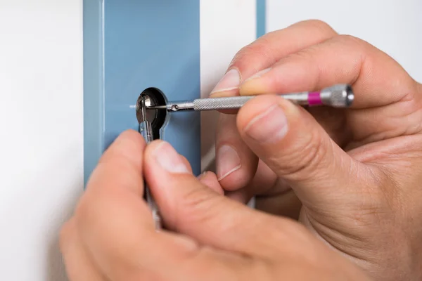 Lockpicker fixação maçaneta da porta em casa — Fotografia de Stock