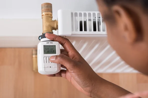 Mulher ajustando a temperatura no termostato — Fotografia de Stock