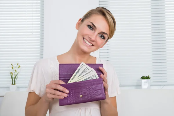 Gelukkige vrouw geld In de portemonnee tonen — Stockfoto