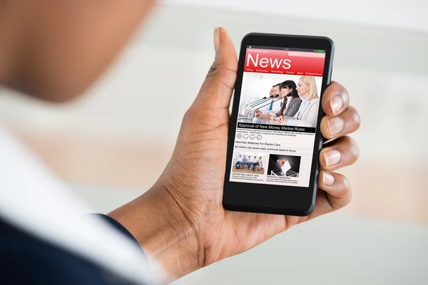 Vrouw lezing nieuws op mobiele telefoon — Stockfoto