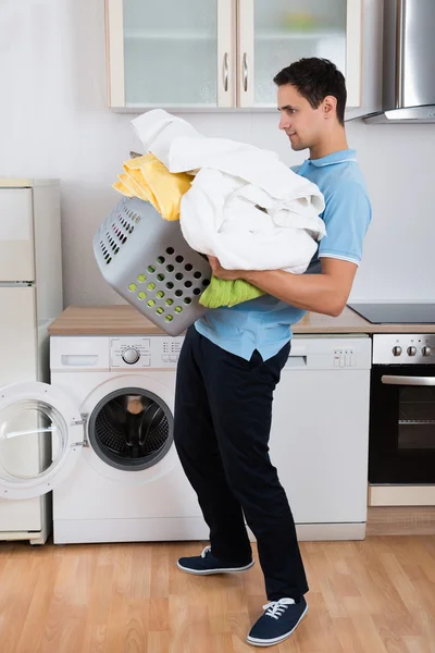Adam taşıyan ağır çamaşır sepeti — Stok fotoğraf