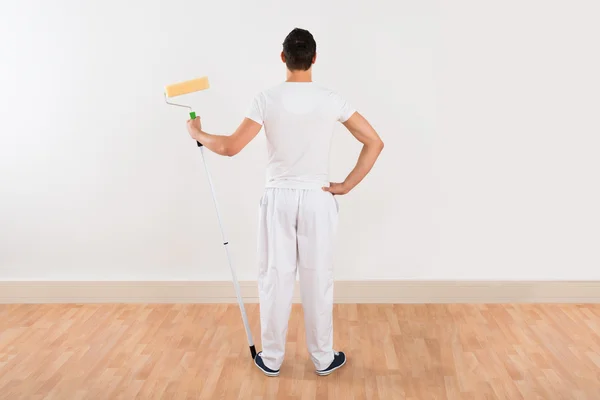 Hombre sosteniendo rodillo de pintura — Foto de Stock