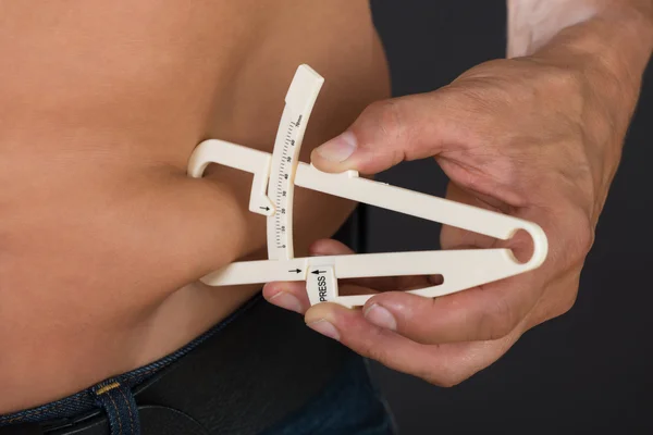 Shirtless άνθρωπος μέτρησης λίπους στο στομάχι — Φωτογραφία Αρχείου