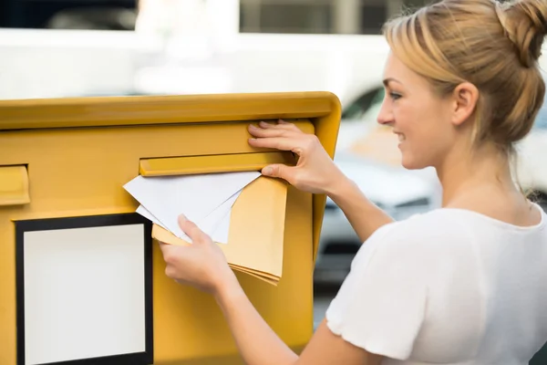 Mujer insertando carta en el buzón — Foto de Stock