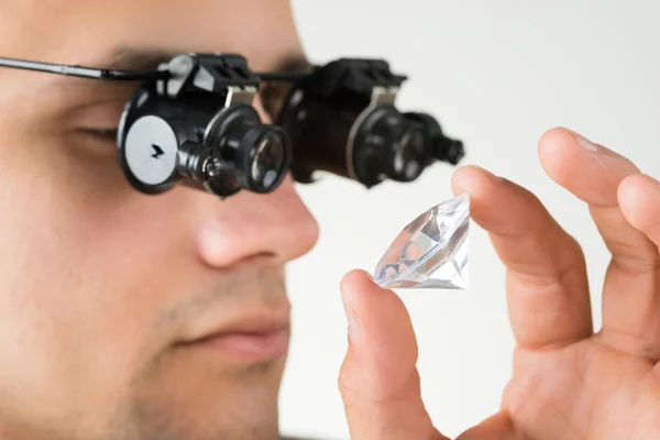 Joalheiro examinando diamante com lupa — Fotografia de Stock