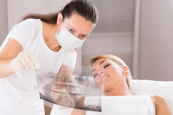 Dentista mostrando raios-X dos dentes para o paciente — Fotografia de Stock