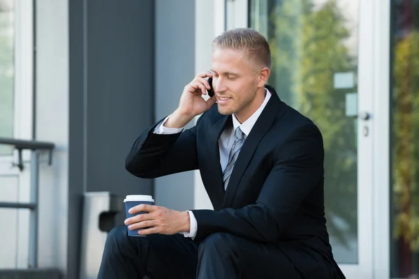Hombre de negocios mirando el teléfono celular — Foto de Stock