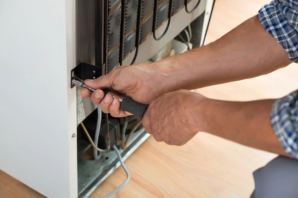 Serviceman Working On Fridge At Home — Stock Photo, Image