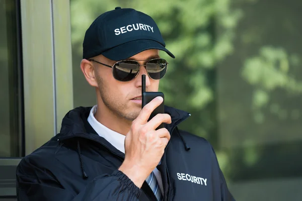 Joven guardia de seguridad hablando en Walkie-talkie —  Fotos de Stock