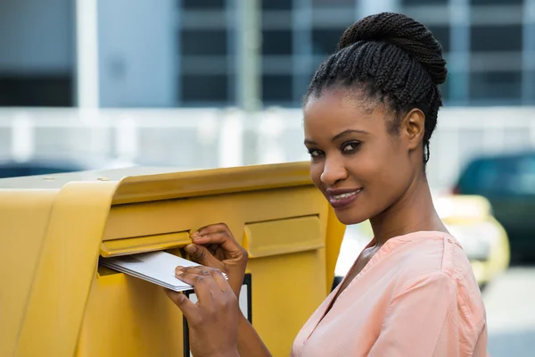 Frau steckt Brief in Briefkasten — Stockfoto