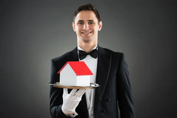 Happy Waiter Holding House Model — Stock Photo, Image