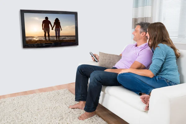 Casal assistindo televisão no sofá — Fotografia de Stock