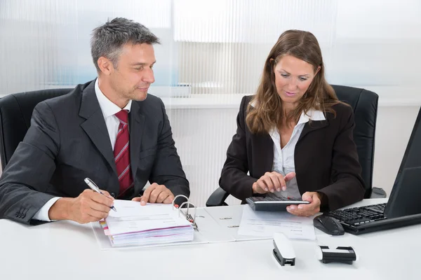 Two Businesspeople Calculating Tax In Office — Stock Photo, Image