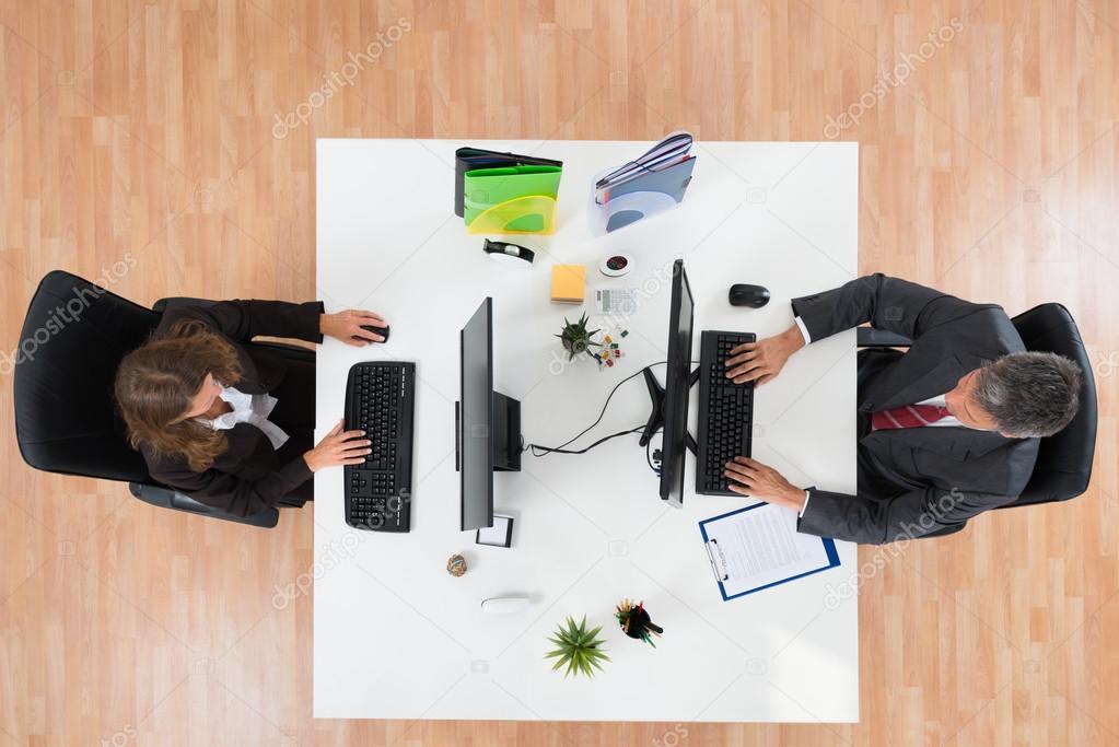 Two Businesspeople Working On Computers