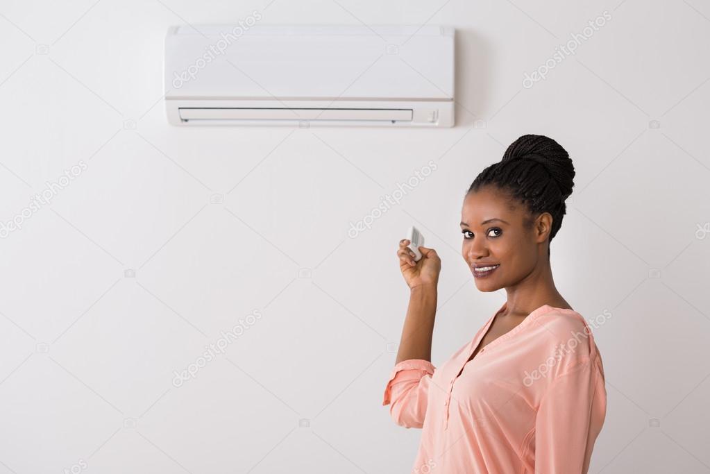 Woman Operating Air Conditioner