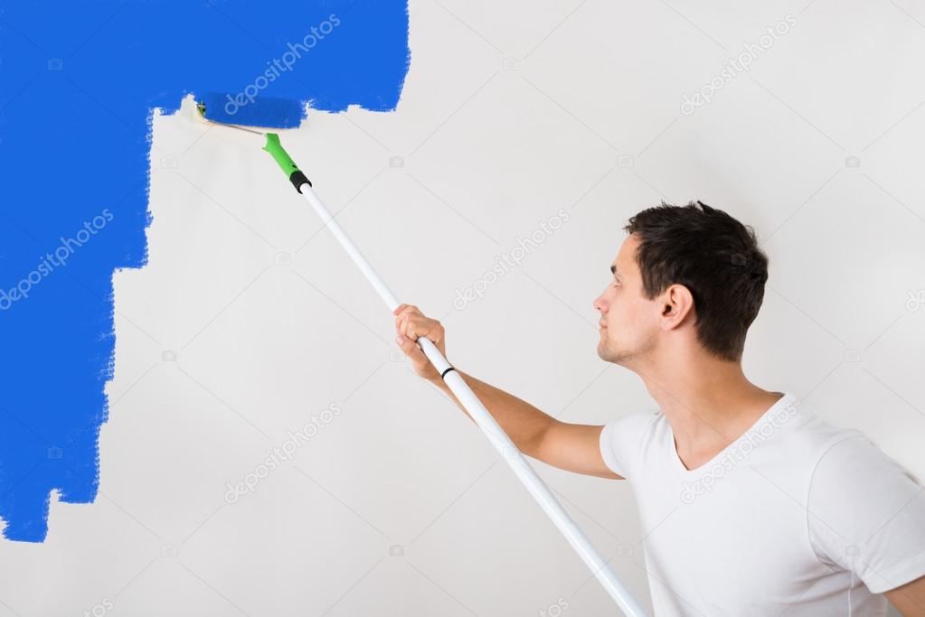 Man Painting Wall With Blue Paint