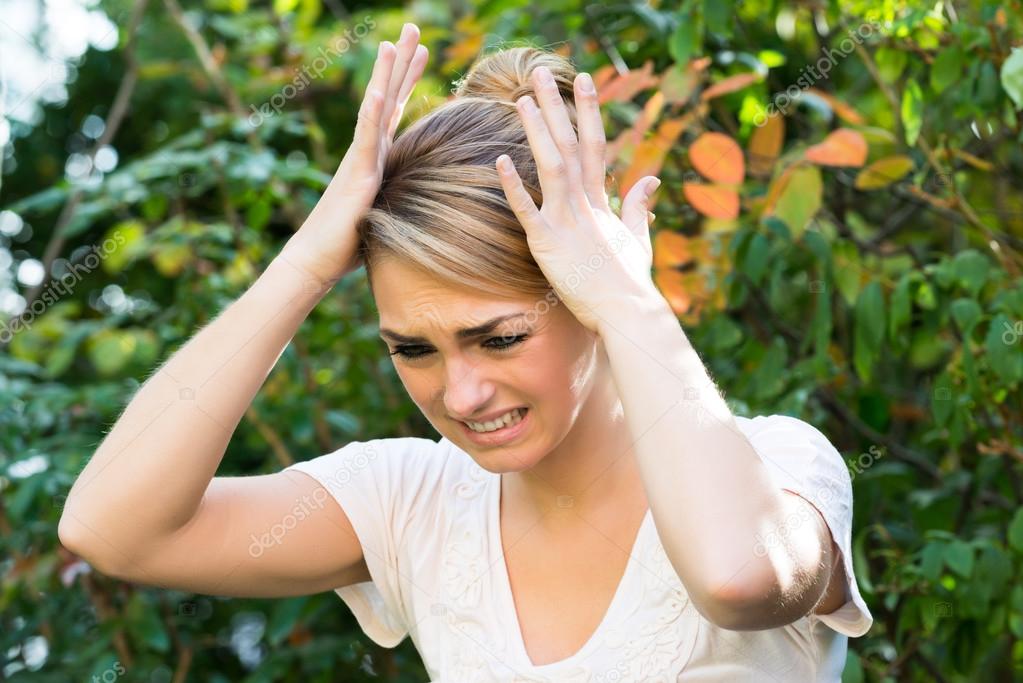 Woman With Hands On Head Against Plants