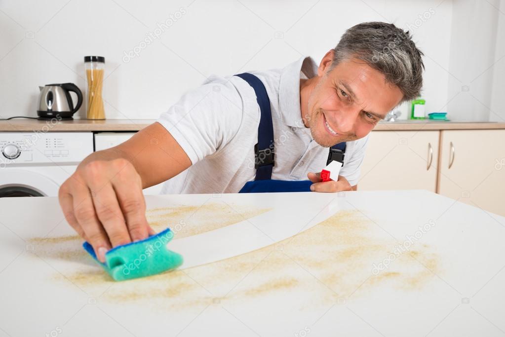 Janitor Cleaning Counter With Sponge At Home