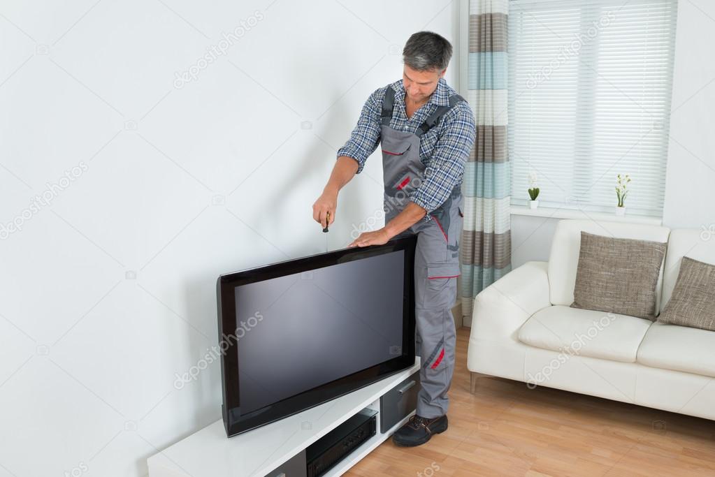 Technician Installing Television At Home