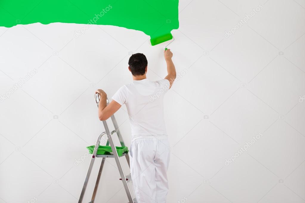 Man Painting Wall With Green Paint