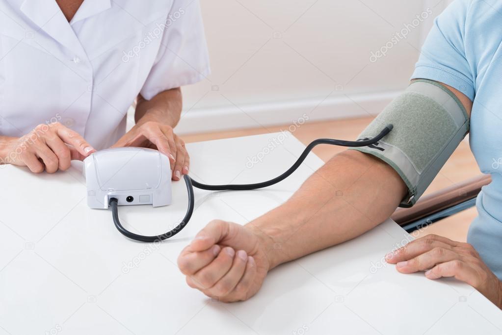 Doctor Checking Blood Pressure Of Patient