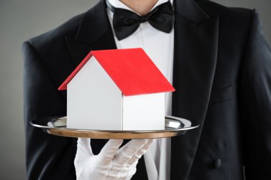 Ev modeli içinde tepsi tutarak garson