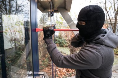 Kapıyı açmak için levye kullanan adam