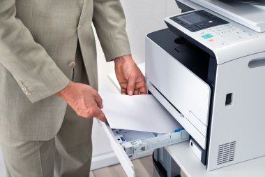 Businessman Using Printer In Office clipart