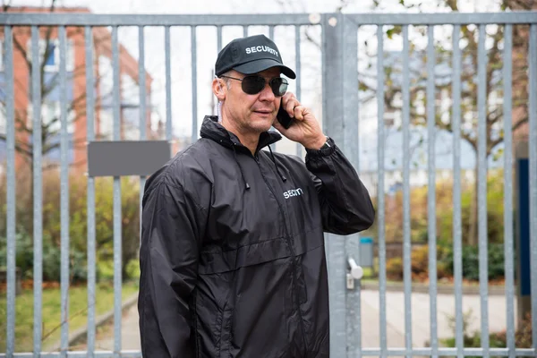 Security Guard praten op mobiele telefoon — Stockfoto