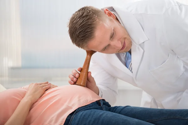 Doctor escuchando el ritmo cardíaco del feto — Foto de Stock