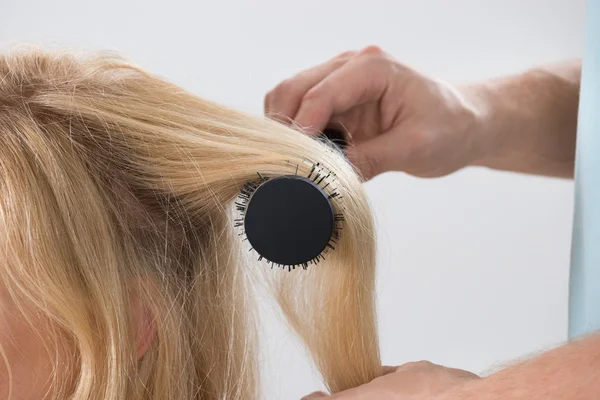 发型师刷牙女人的头发 — 图库照片