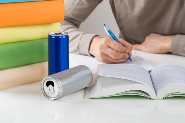 Estudiante masculino escribiendo en libro en la mesa — Foto de Stock