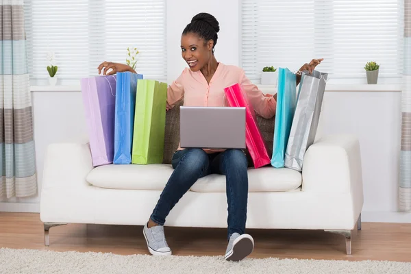 Aufgeregte Frau sitzt auf Sofa — Stockfoto